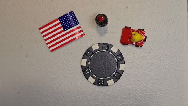 Poker chip duck with a tiny red race car and an American flag sticker
