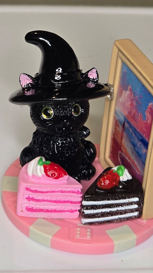 Pink poker chip with a witch-hat cat and miniature cake slices